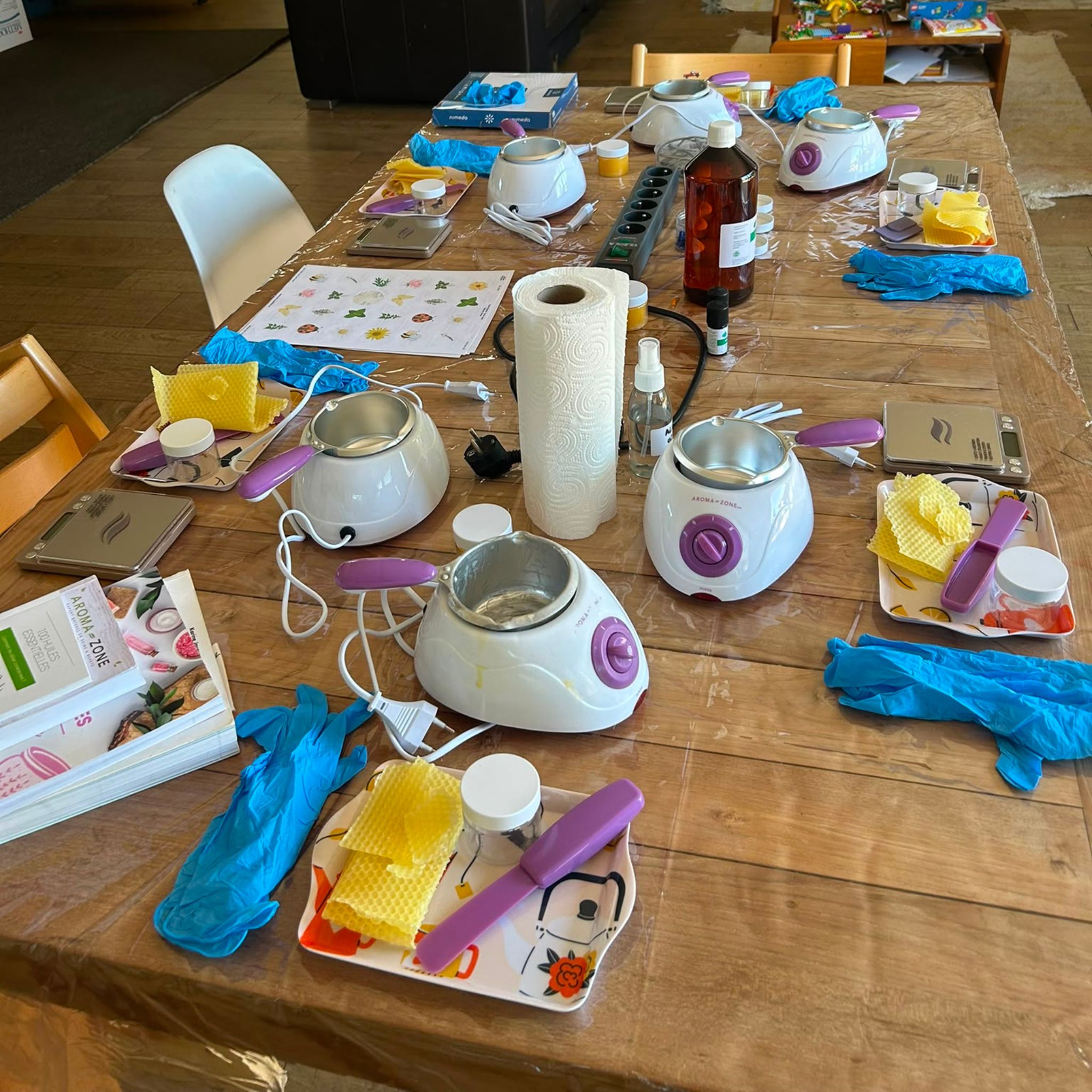 Matériel installé pour l'atelier enfant : fondoirs à cire, cire d'abeille et huiles essentielles